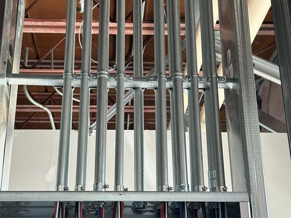 EMT conduit risers dropping into electrical panels in a commercial building