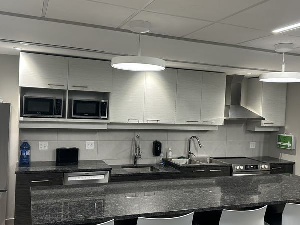 Pendant lighting over a kitchen island in a commercial staff kitchen